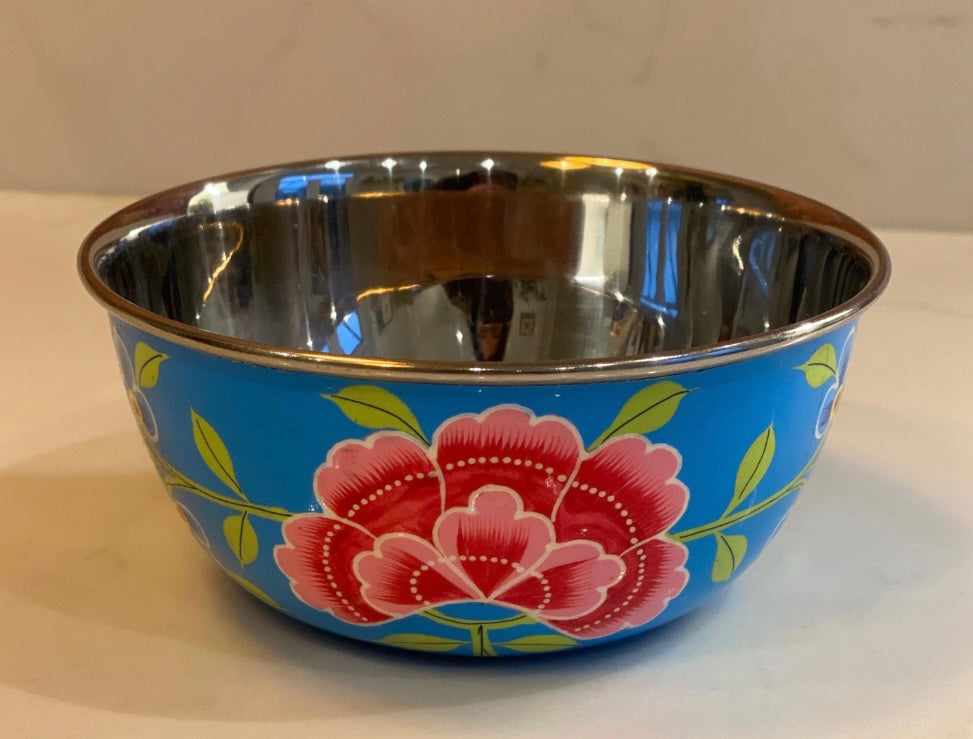 Stainless steel bowl with floral design on a blue background