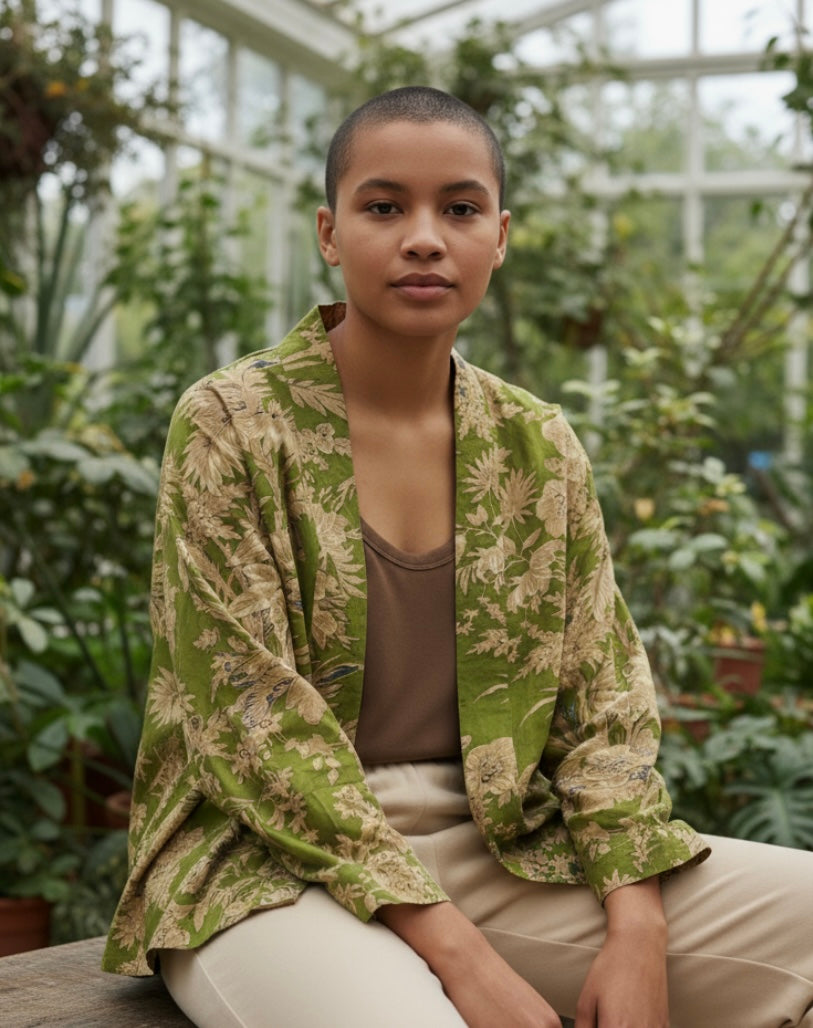 Person wearing a green patterned jacket in a greenhouse setting