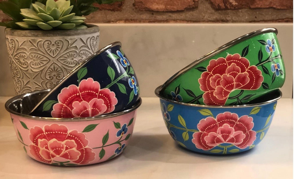 Set of colorful ceramic bowls with floral designs on a neutral background