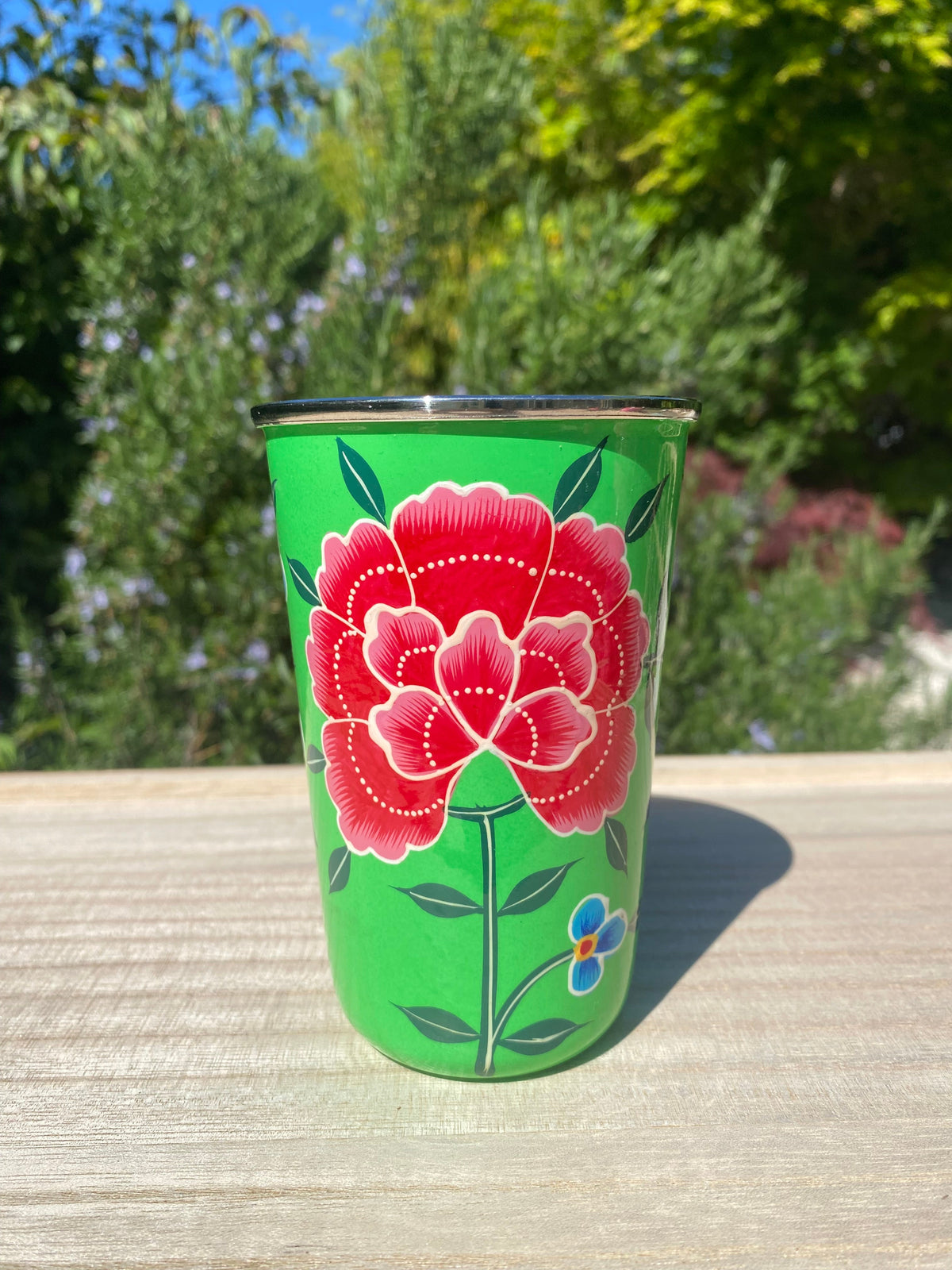 green tumbler with red flower.  Enamel outer and stainless steel inside