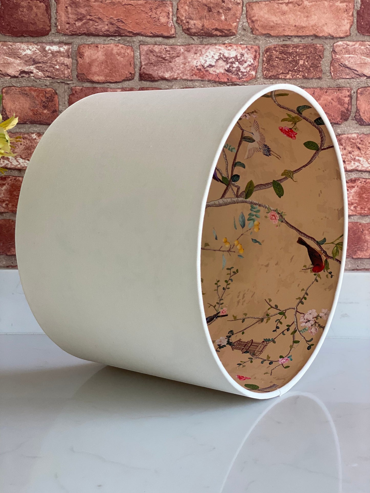 The Bamboo Bird handmade cream linen drum lampshade with a decorative gold chinoiserie bird and botanical lining