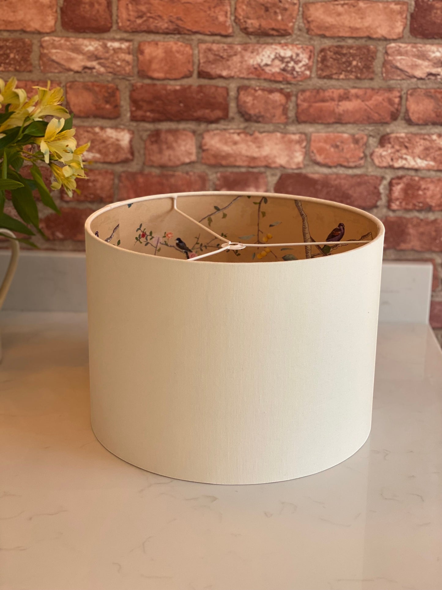 The Bamboo Bird cream linen drum lampshade with a decorative gold chinoiserie bird and botanical interior lining.