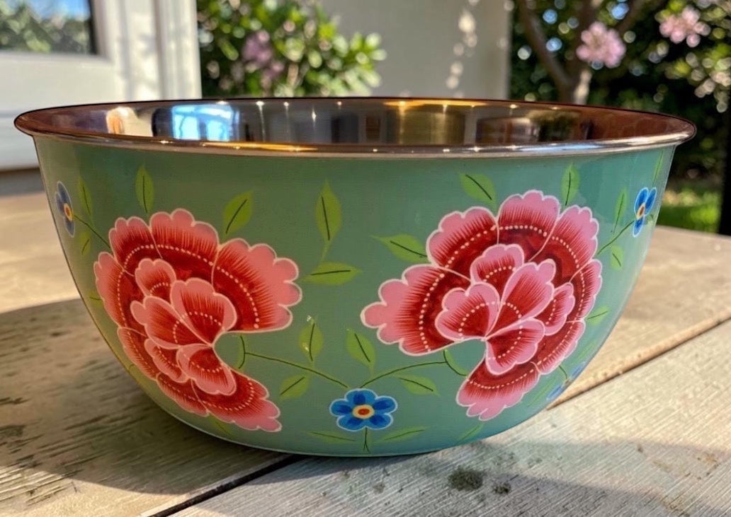 The Bamboo Bird hand-painted stainless steel and enamel bowl in sage green with pink floral patterns.