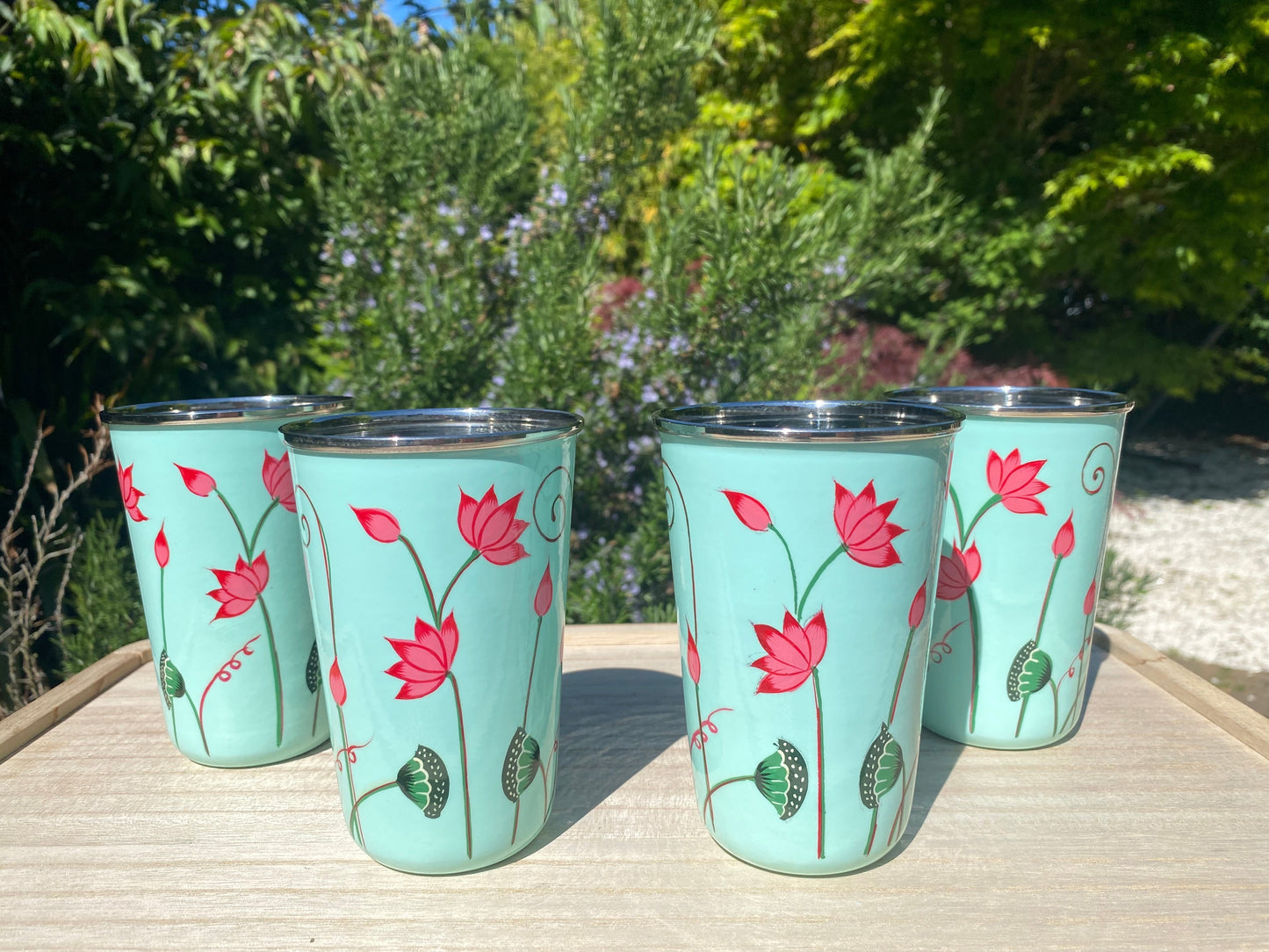 The Bamboo Bird set of four light blue stainless steel tumblers with hand-painted pink lotus flower designs