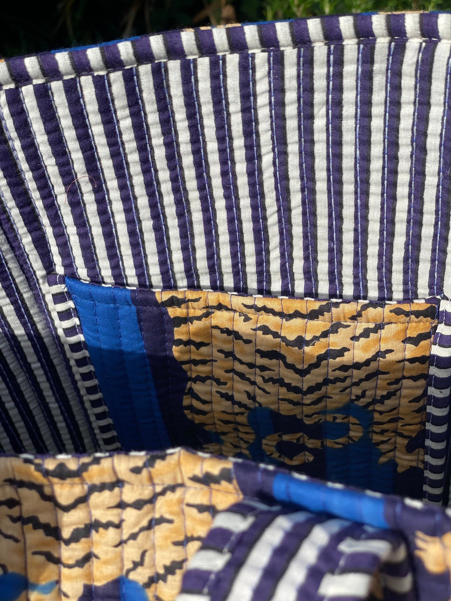 The Bamboo Bird quilted cotton tote bag featuring a blue and white striped pattern with a tiger print pocket