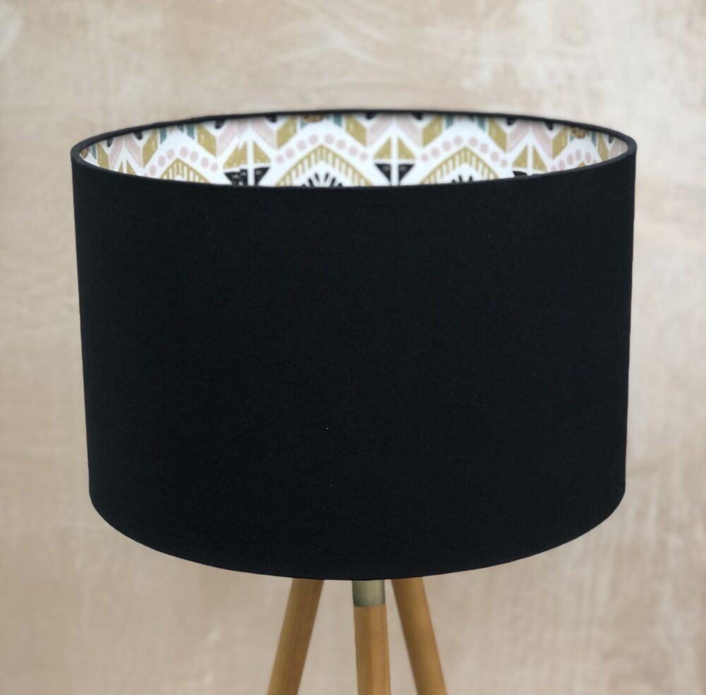 *black lampshade with tiger lining on tripod lamp