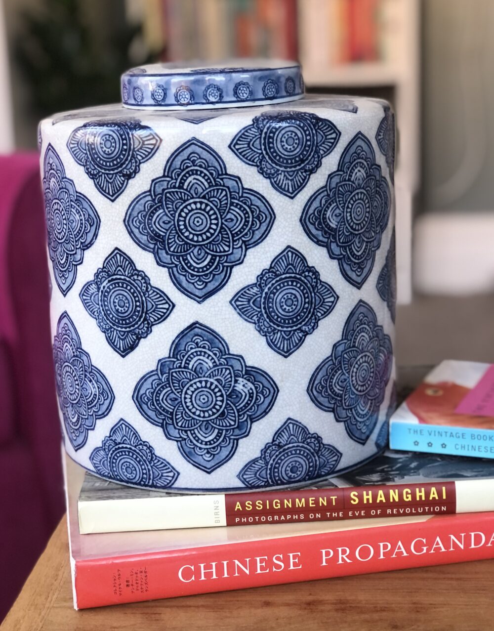 * blue and white geometric patterned ginger jar on books